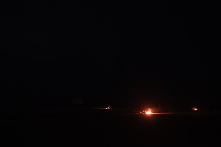two fires on a beach at night